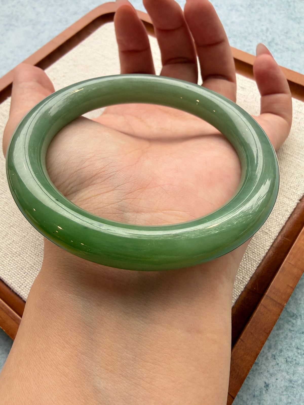Hand holding the green jadeite bangle