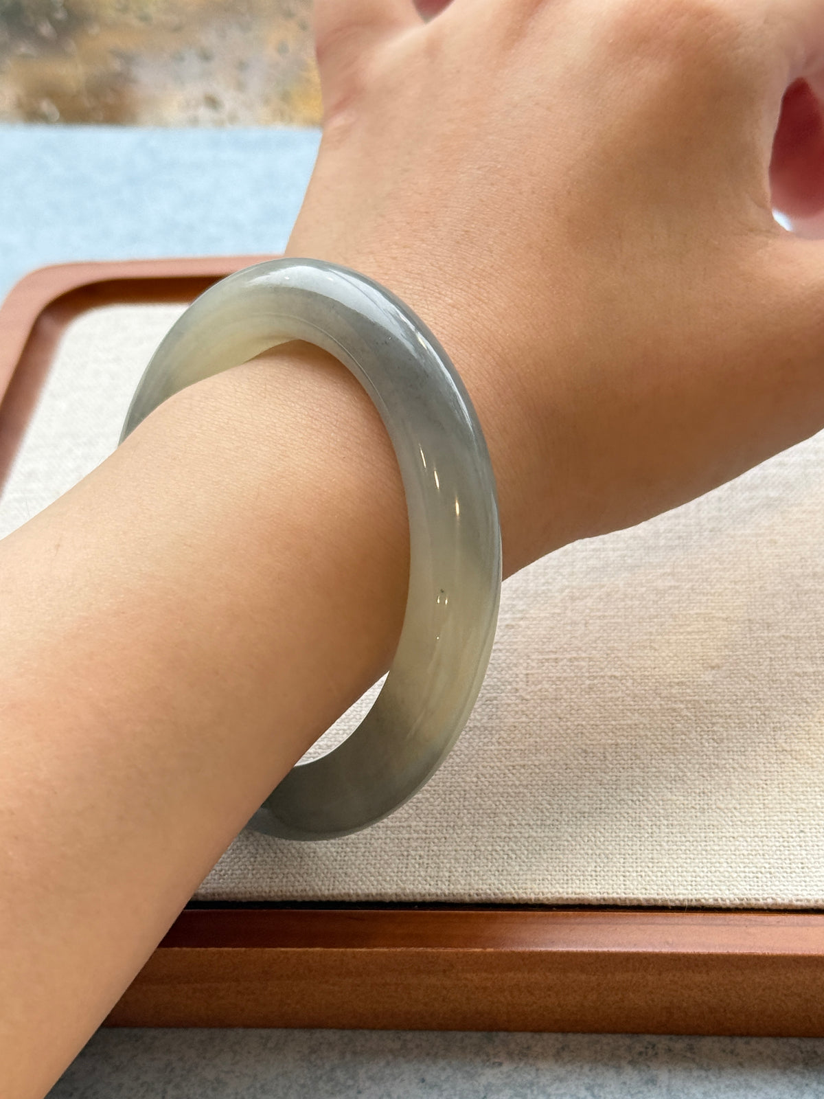 Grey jadeite bangle on wrist, side view