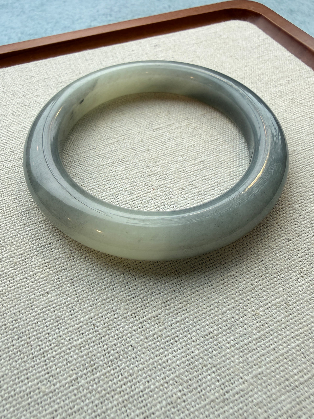 Grey jadeite bangle laid flat on tray