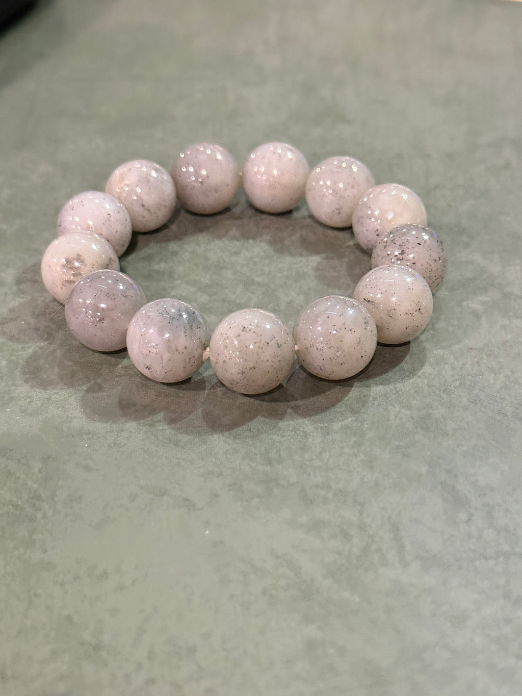 Grey jadeite bead bracelet with black speckles, laid flat