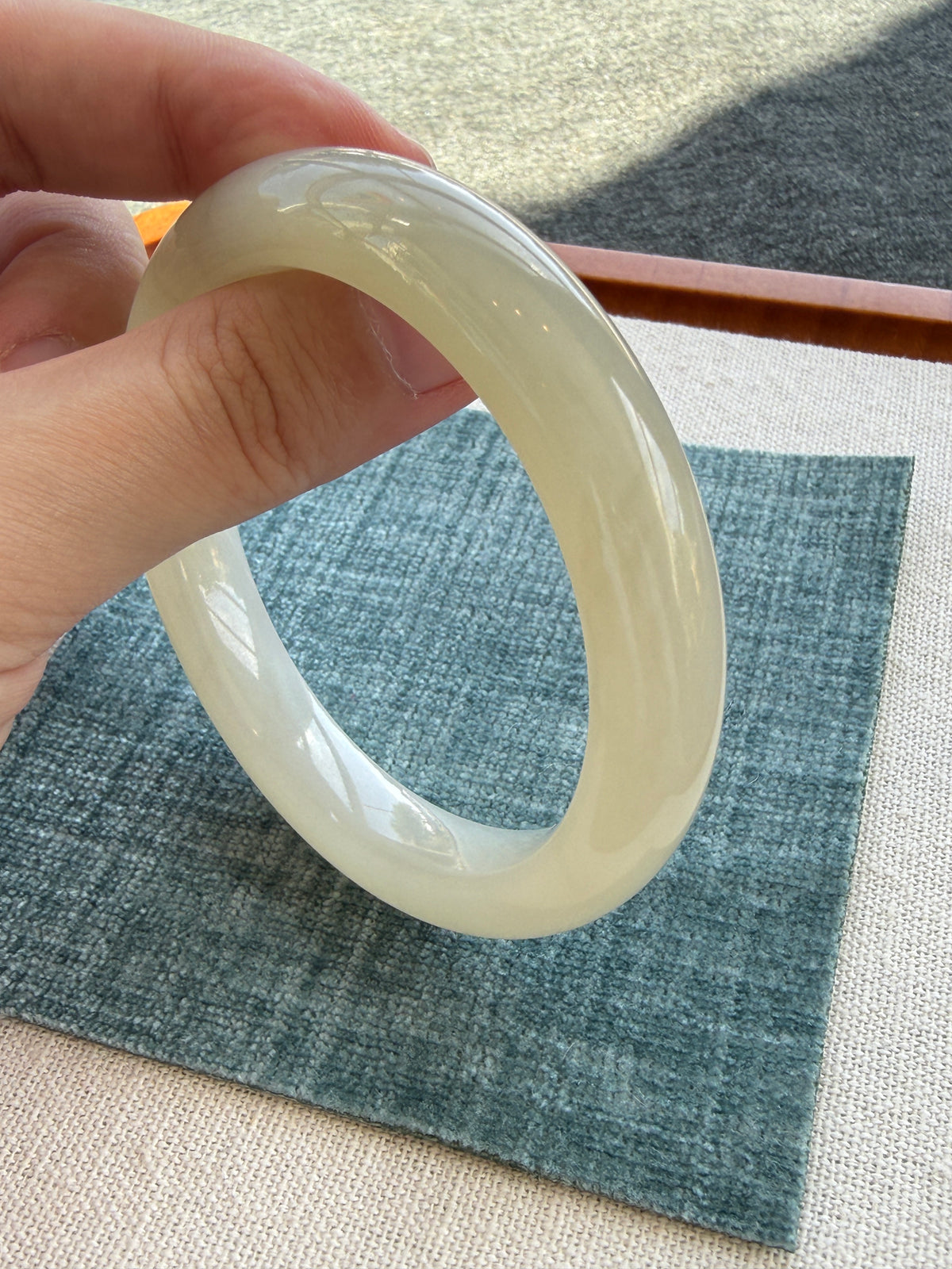 White hetian jade bangle on blue cloth — CongCong Jade
