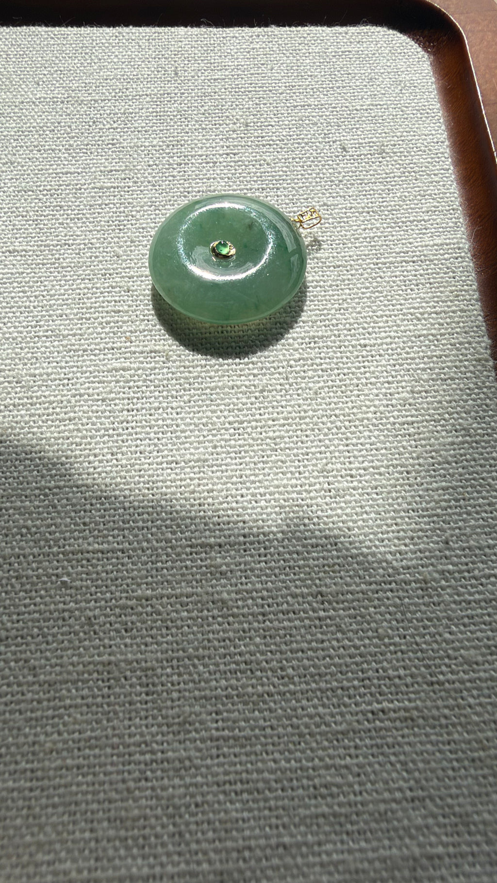Green jadeite donut pendant on tray — CongCong Jade